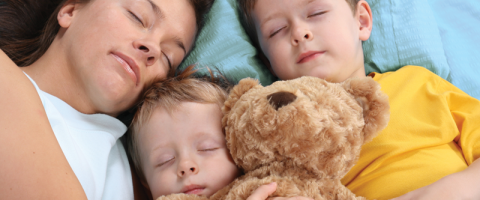 Family sleeping in a bed