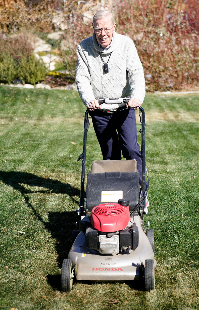 Senior male pushing a lawn mower