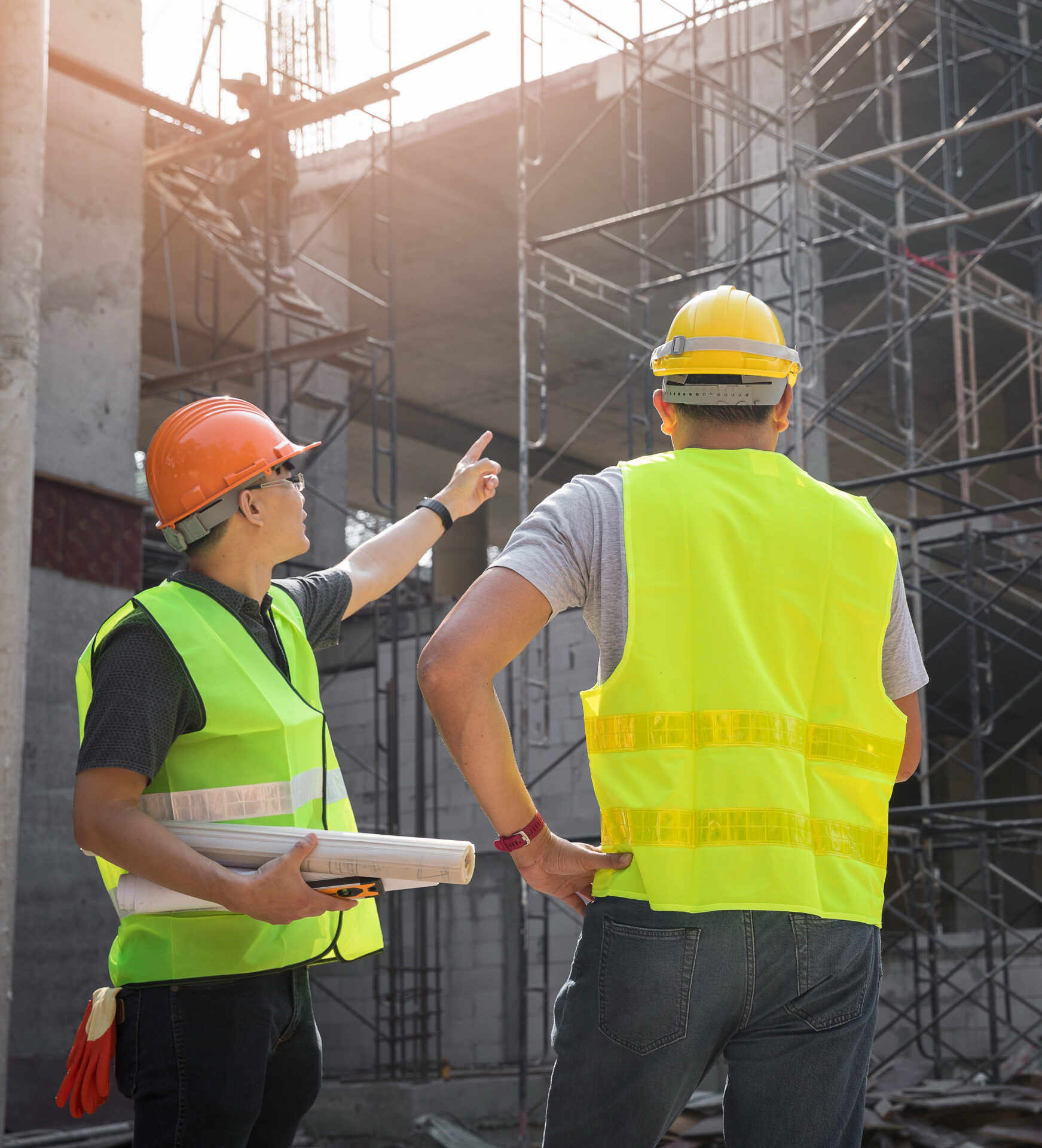 Engineer discussing with foreman about project in building construction site.